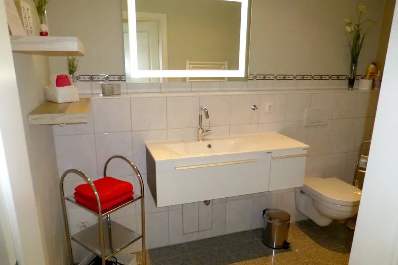 Bad mit Waschtisch, beleuchtetem Spiegel und WC