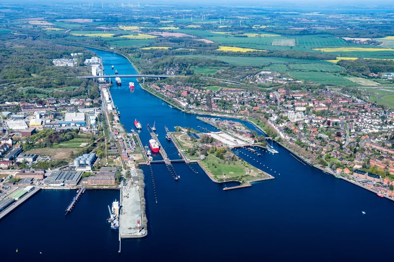 Luftbild der Schleusen Kiel-Holtenau am Nord-Ostsee-Kanal mit Schiffen in den Kammern, dahinter Hochbrücke und Kanal